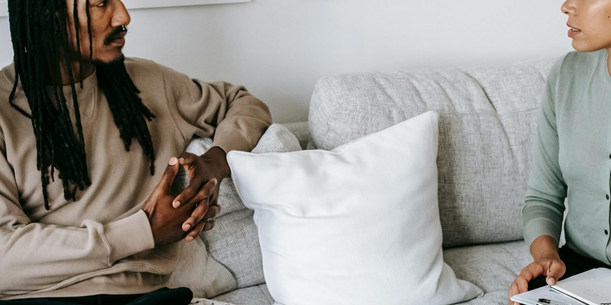 A therapist and client engaging in a calm, trust-building conversation.