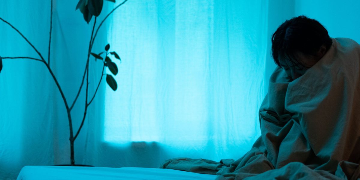 A person looking thoughtful and slightly uncomfortable in a social gathering, capturing the initial feelings of social anxiety.