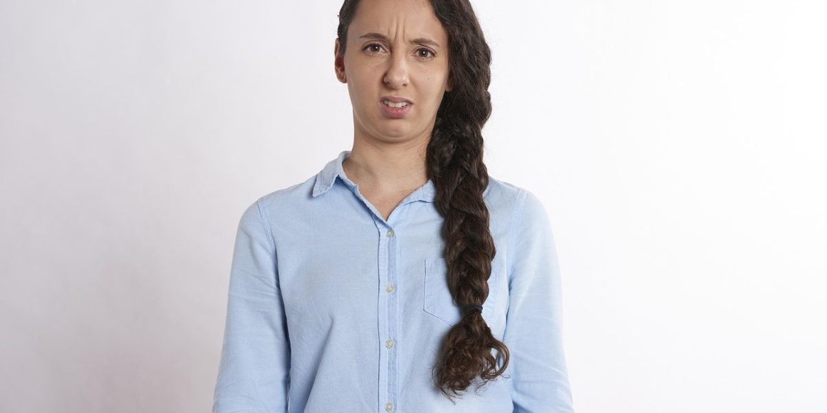 A person looks thoughtful and slightly concerned, symbolizing the internal struggle to articulate complex emotions.