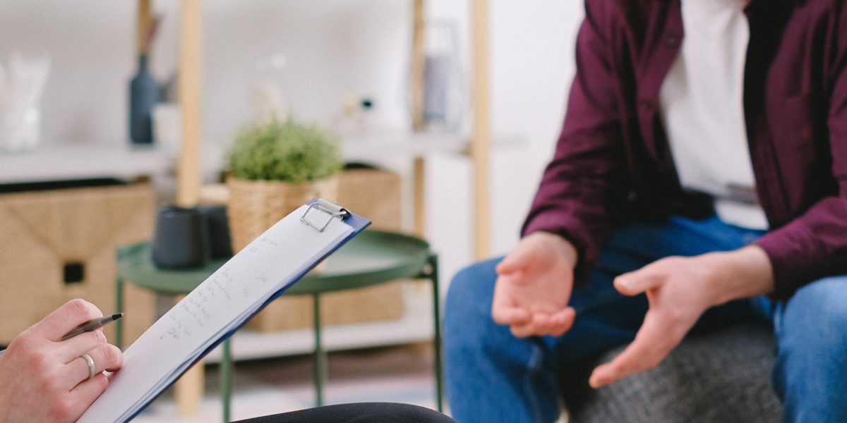An individual engaging in a supportive conversation with a therapist, exploring their feelings and seeking guidance.