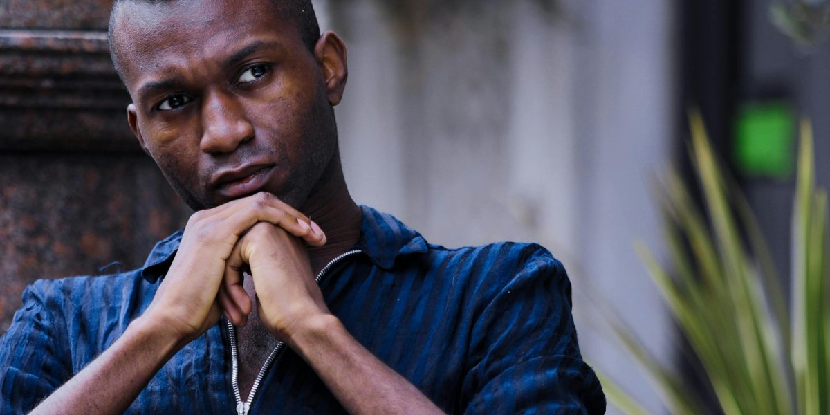 A person sits thoughtfully, perhaps reflecting on past experiences or contemplating their mental well-being.