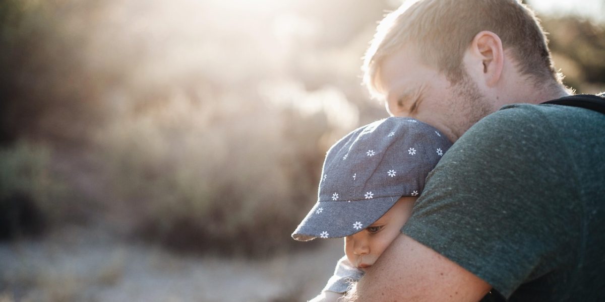 A happy family enjoying time together outdoors, representing the long-term well-being achieved through effective parenting therapy.