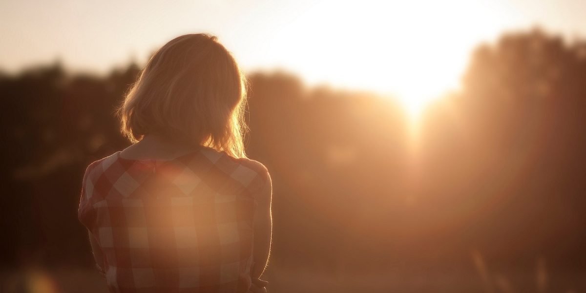 A person sitting alone, head in hands, conveying a sense of quiet struggle and confusion often associated with anxiety.