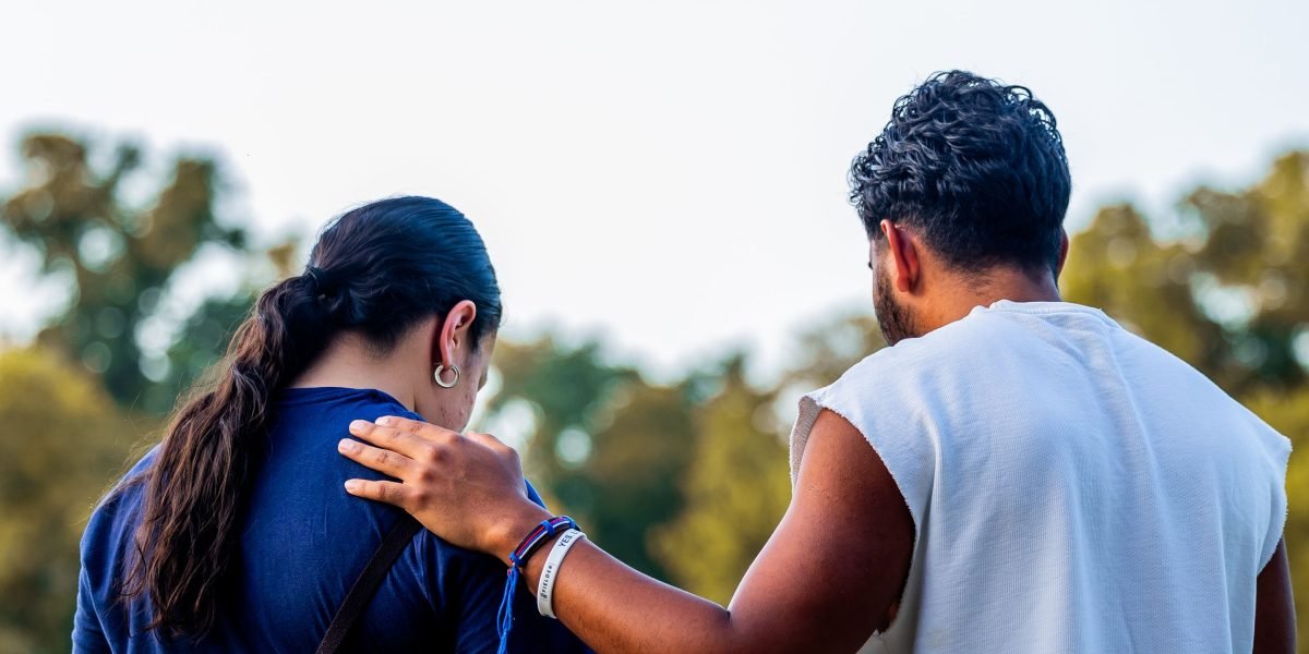 Two people engaged in a supportive conversation, one listening actively to the other, illustrating professional or peer support.