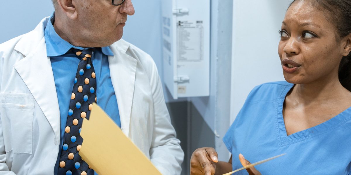A group of medical professionals collaborating, reviewing documents, and discussing a patient's care plan.