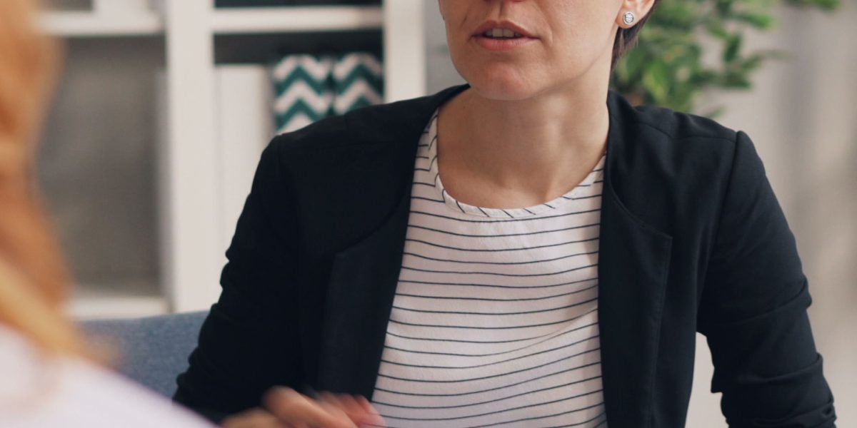 A therapist actively listening to a patient in a comfortable, private office setting, representing a diagnostic assessment.